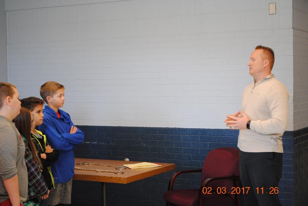 A member of the Sheriff's Office speaing with several students from the Heber Springs fourth grade class. 