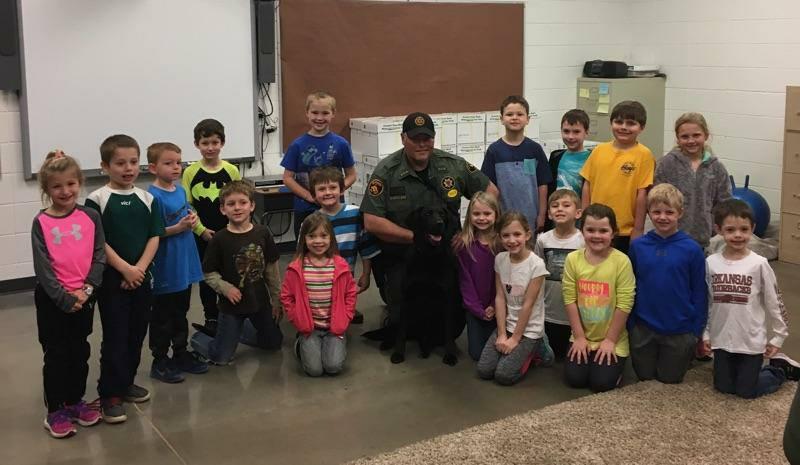 Heber Springs Elementary School students pose with Deputy McLain and K9 Zeke.