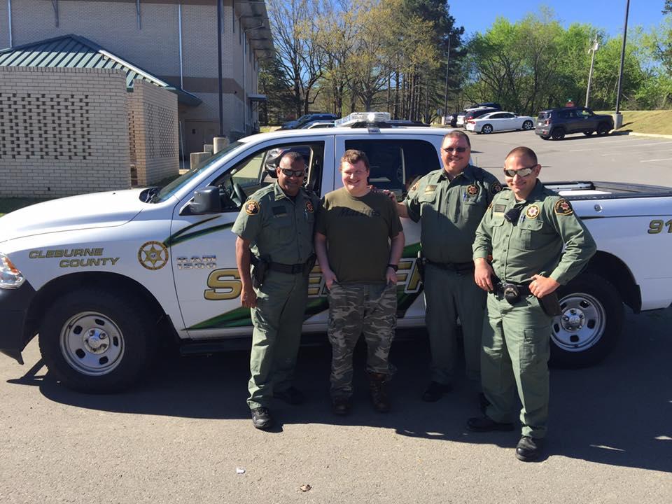 A student standing with officers.