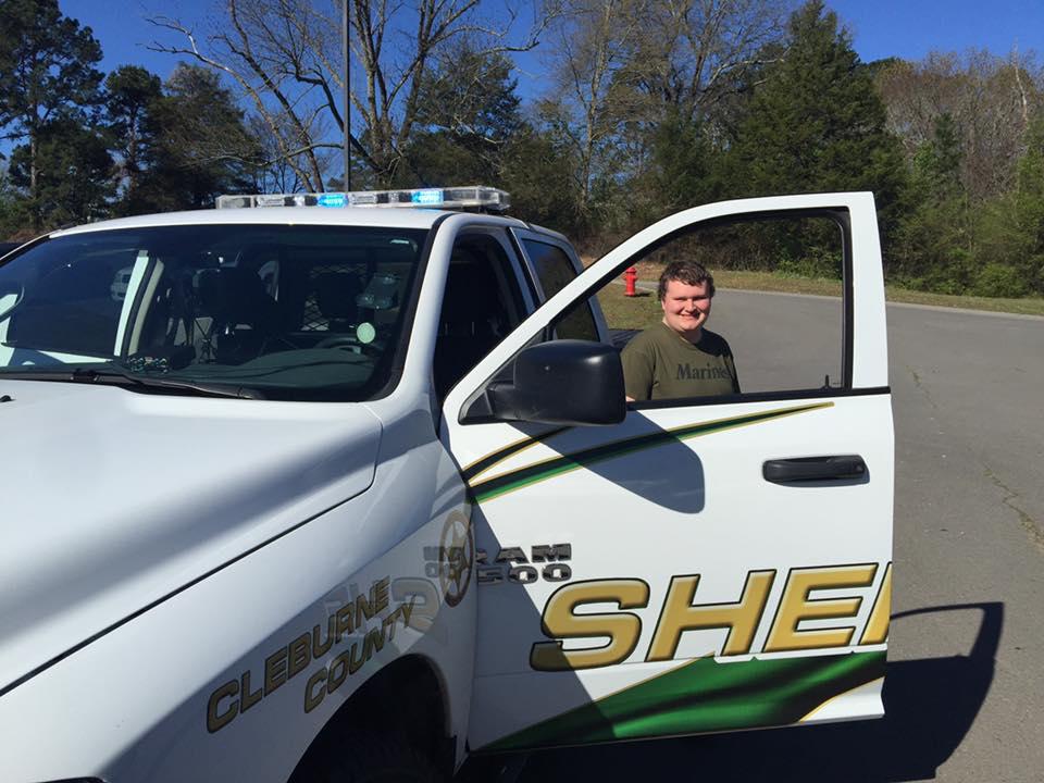 Student standing with the Sheriff's truck.