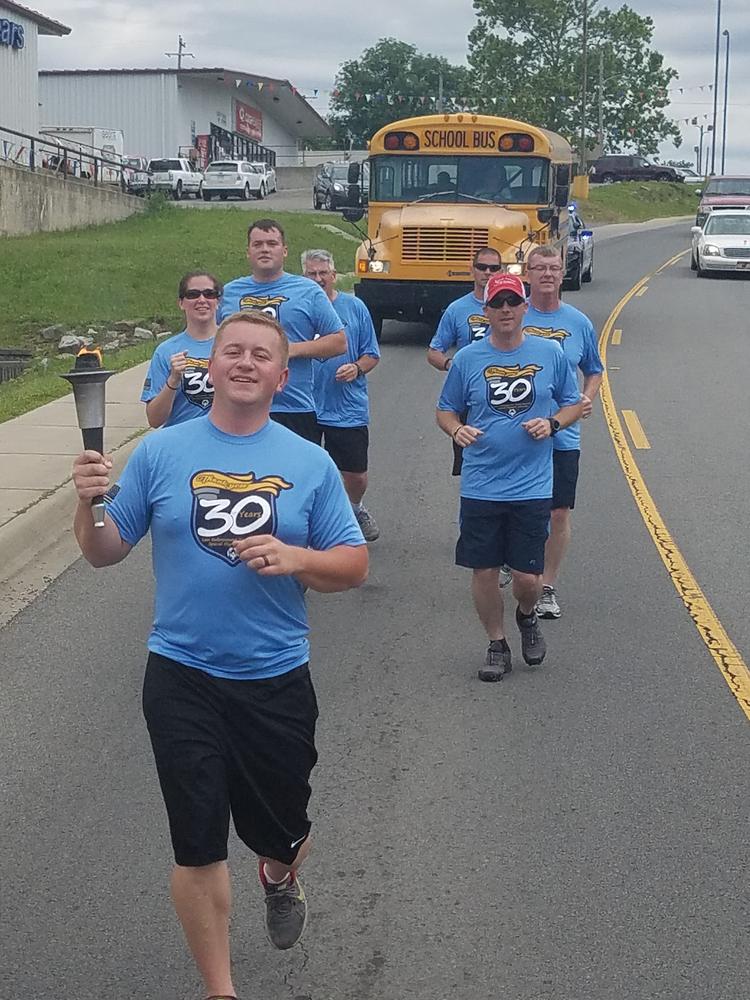 Young man leading the torch run while holding the torch.