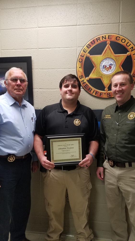 Officer Woodson receiving award from Alan Roberson and Sheriff Brown.