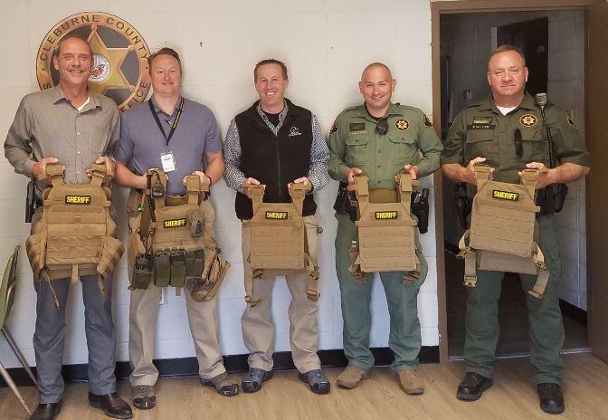 Sheriff Brown and four others holding rifle body armor. 