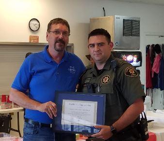 Deputy Austin Miller receiving certificate of appreciation from The Other Side member.
