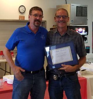 Lieutenant Jeff Bittle receiving certificate of appreciation from The Other Side member.