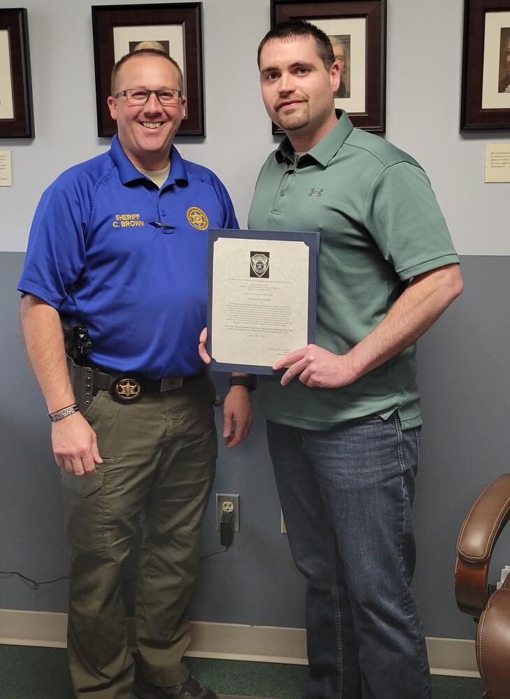 Detective Brandon Long receiving Citation of Excellence commendation from Sheriff Chris Brown.
