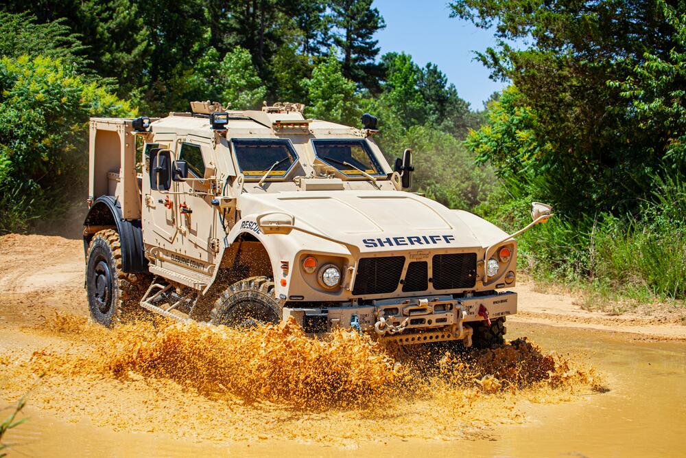 An ARV driving through a large mud puddle.