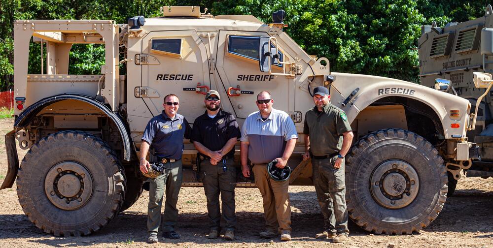 Sheriff Chris Brown standing with three others in front of an ARV.